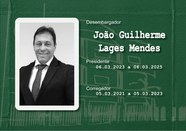 Foto de busto preta e branca do Desembargador João Guilherme Lages Mendes usando terno escuro e ...